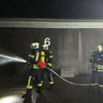 Ein Trupp der Feuerwehr beim Au?enangriff w?hrend der Jahres?bung auf dem Gel?nde von Messebau T?nnissen in N?tterden.